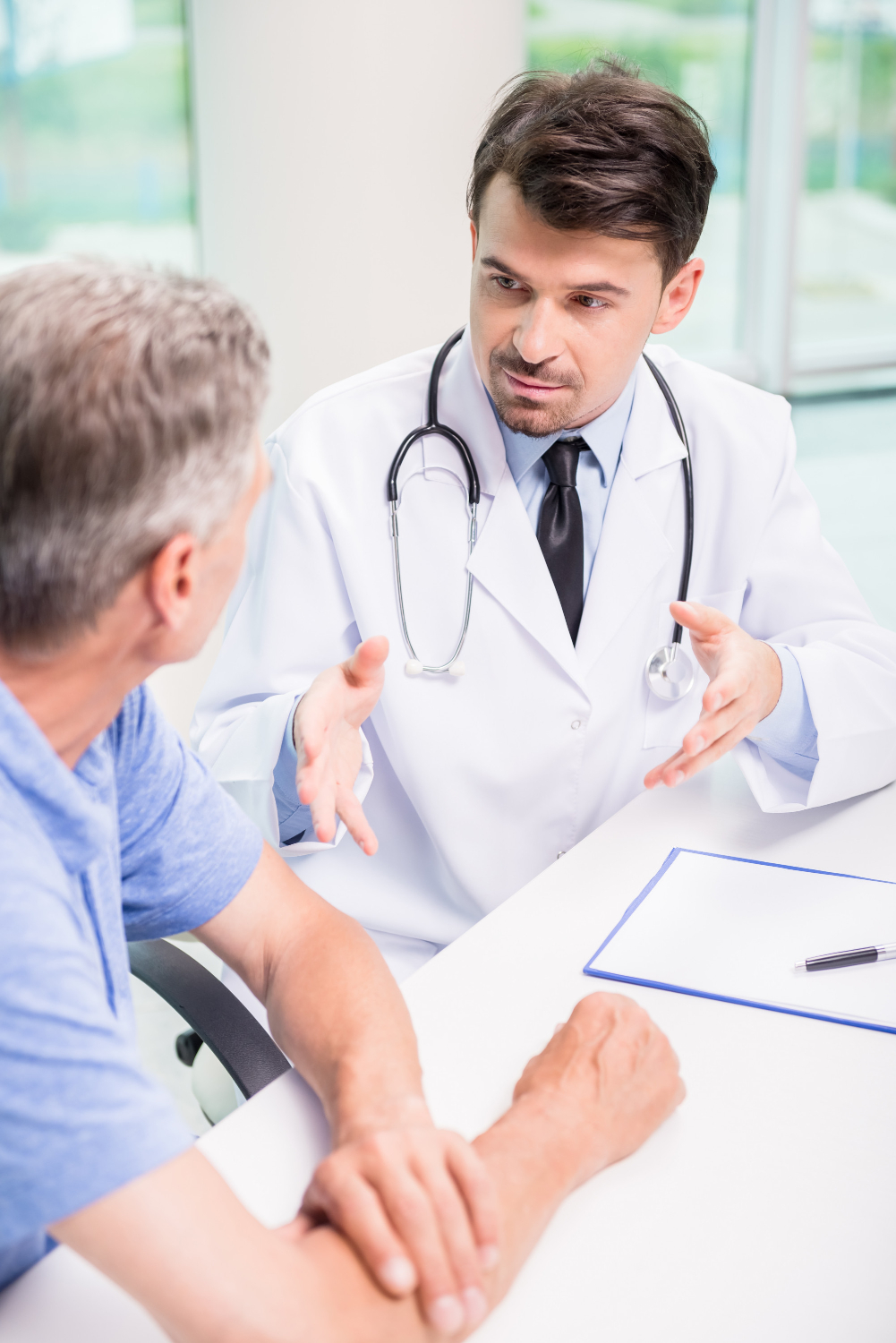male-doctor-talking-with-patient-seriously-clinic